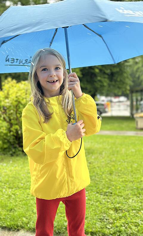 Maedchen mit Schirm bei Regenwetter in Kaernten