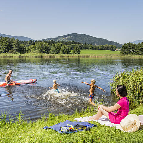 Familie beim Baden und Stand up paddlen im Flatschacher See