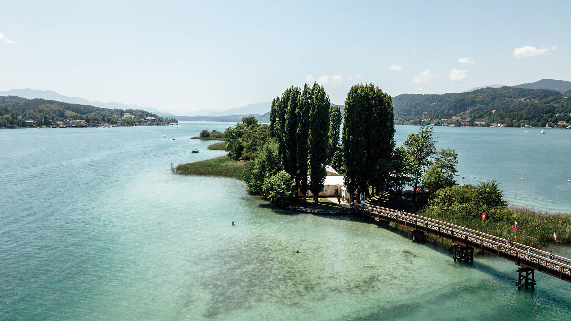 Blick auf die Woerthersee Insel bei Poertschach mit Bruecke verbunden