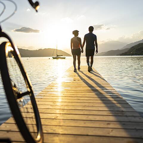 Paerchen am Steg beim Genuss Radfahren am Millstaetter See