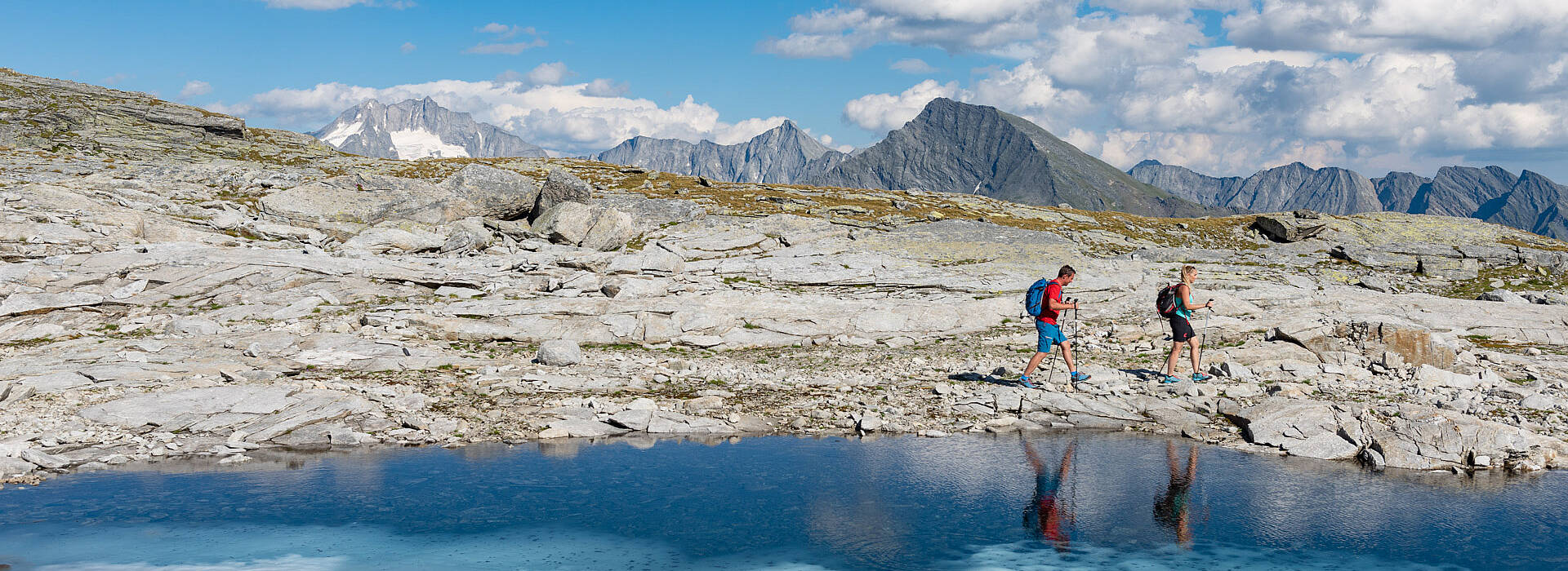 Pärchen beim Wandern am Tauernhöhenweg entlang eines Bergsees