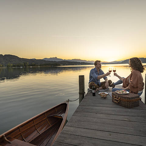 Paerchen beim Picknick am Steg am Woerthersee