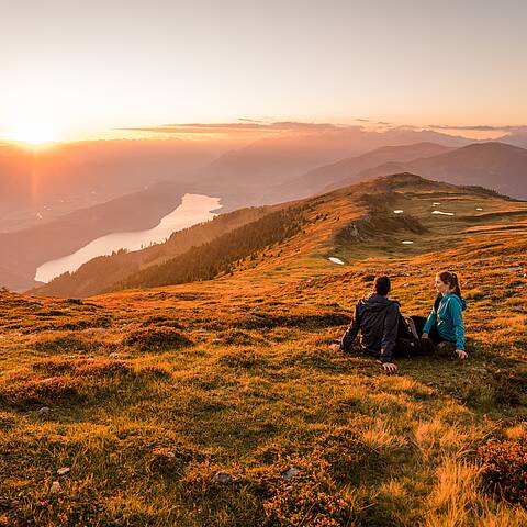 Paerchen beim Wandern am Mirnock mit Blick auf den Millstaetter See