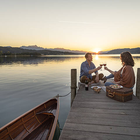 Paerchen beim Picknick am Steg in Poertschach am Woerthersee