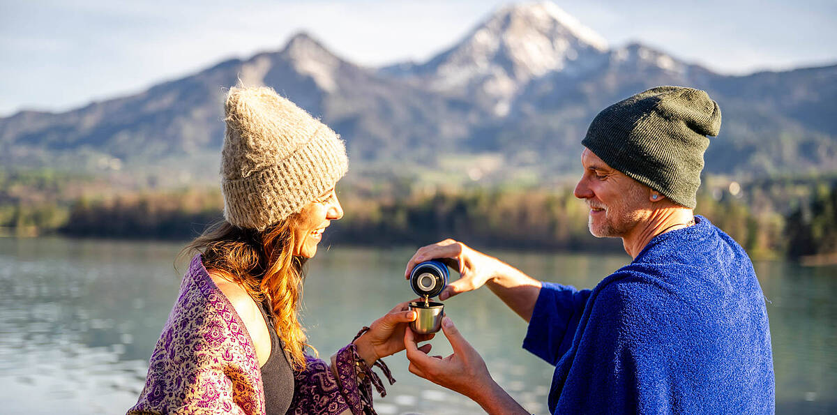 Aufwaermen mit Tee nach dem Kaltbaden im Faaker See