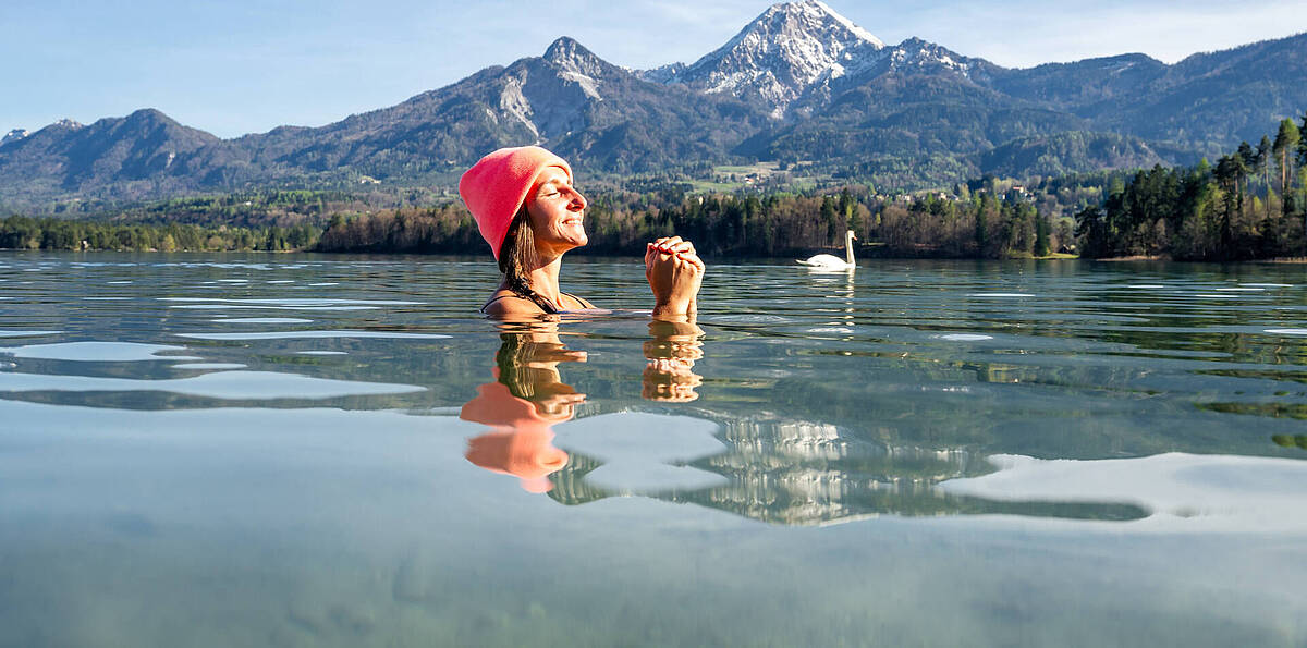 Frau beim Kaltbaden im Faaker See mit Mittagskogel im Hintergrund