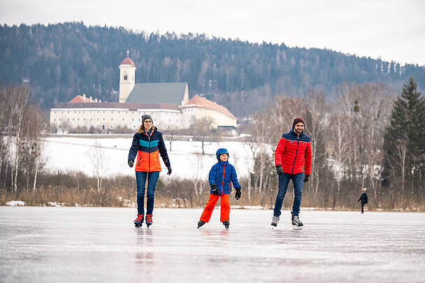 Familie beim Eislaufen am Laengsee in St. Georgen