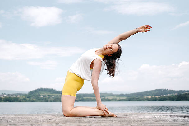 Frau beim Yoga am Steg am Längsee
