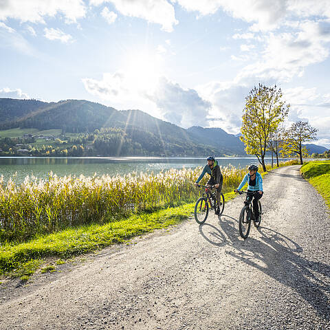 Frau und Mann beim Radfahren im Herbst am schönen Weissensee