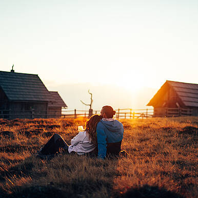 Pärchen genießt den Sonnenuntergang auf der Peterbauerhütte 